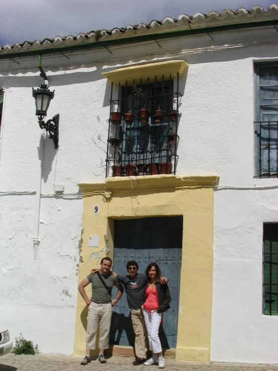 a man and two women standing in front of a building