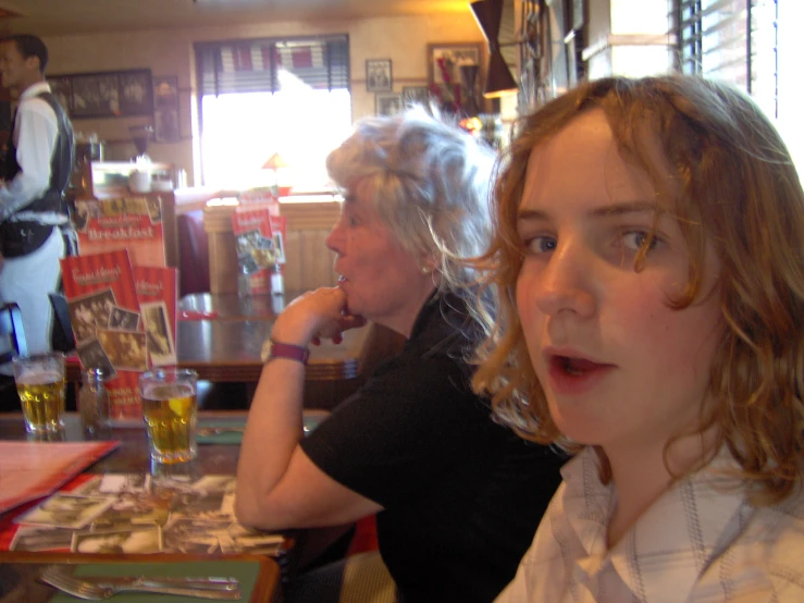 two people sitting at a bar in front of a counter