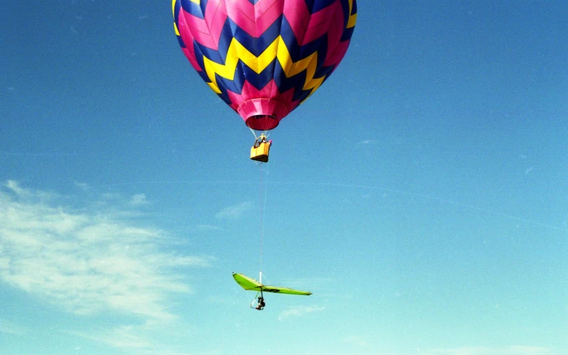 a large colorful balloon being lowered into the air by a kite