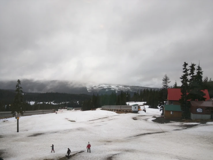 a group of people in the snow near a cabin