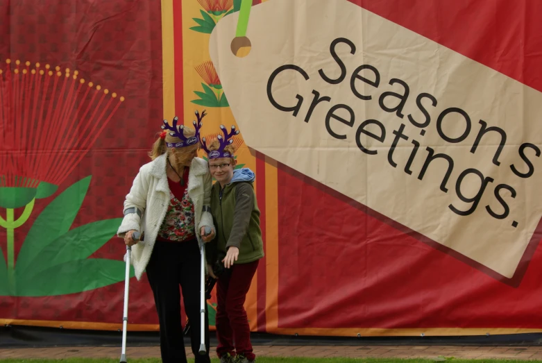 two people in front of a large sign