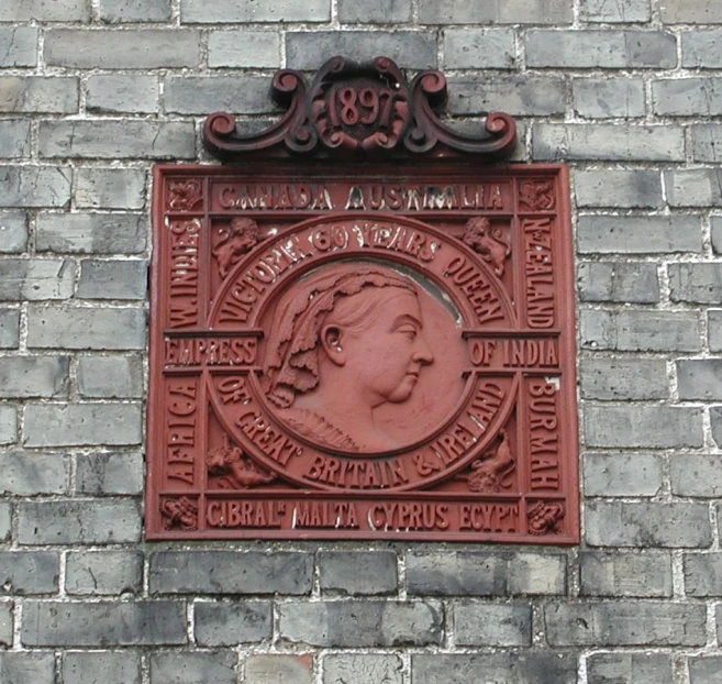 a brick wall with a plaque with a woman on it