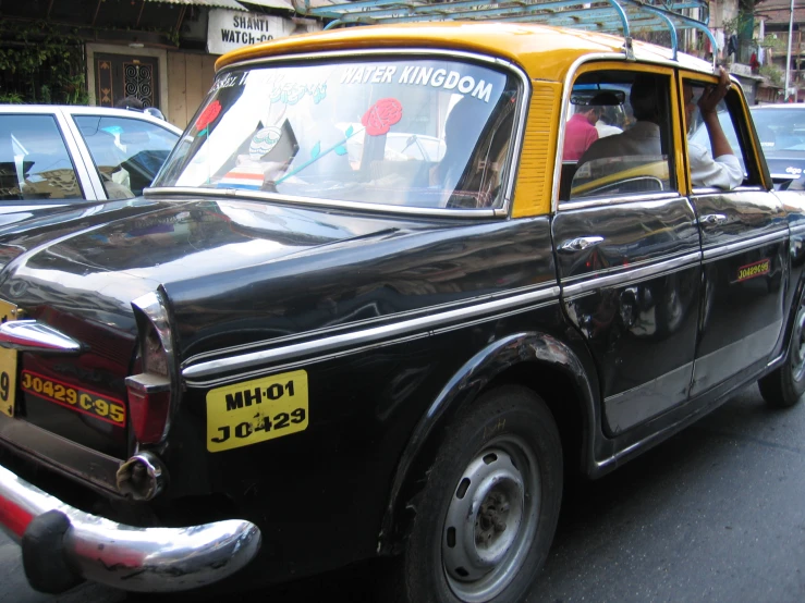 an old school black taxi parked in a row