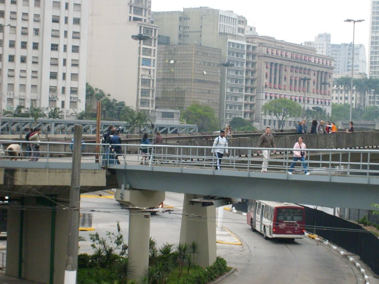 several people on a bridge looking at the city