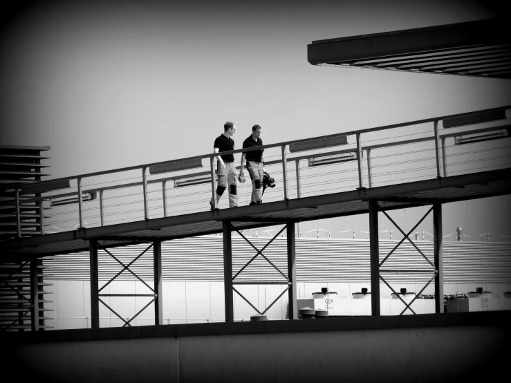 two people walking over a metal bridge together