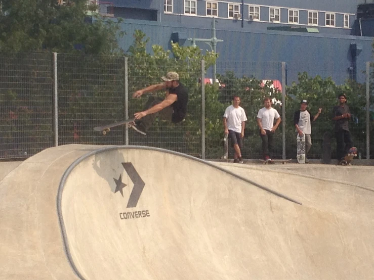 skateboarder high in the air as others look on