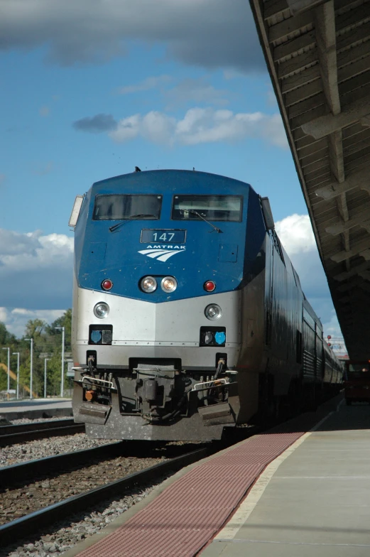 the train is approaching the station on the tracks