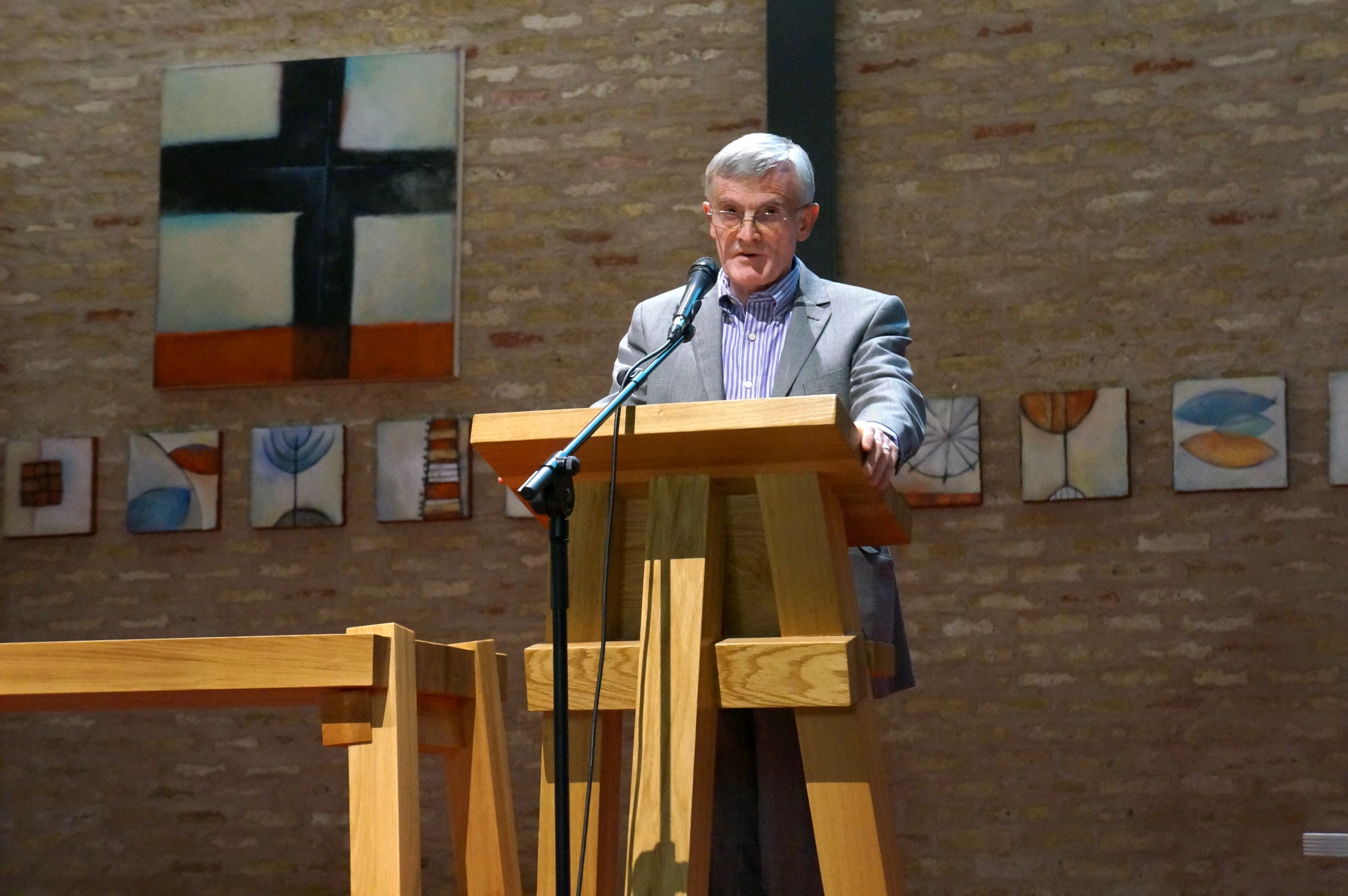 an elderly man at a podium holding a microphone