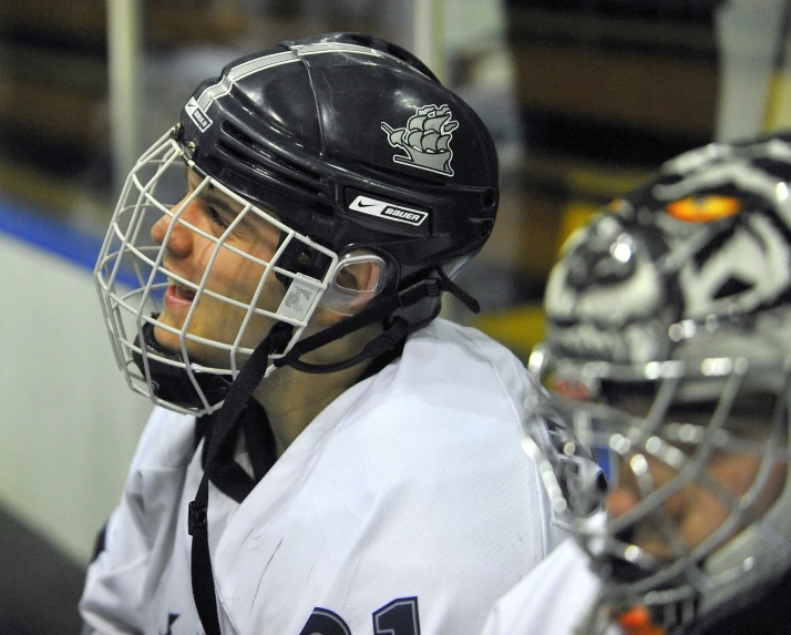 a man in lacrosse gear standing behind another man