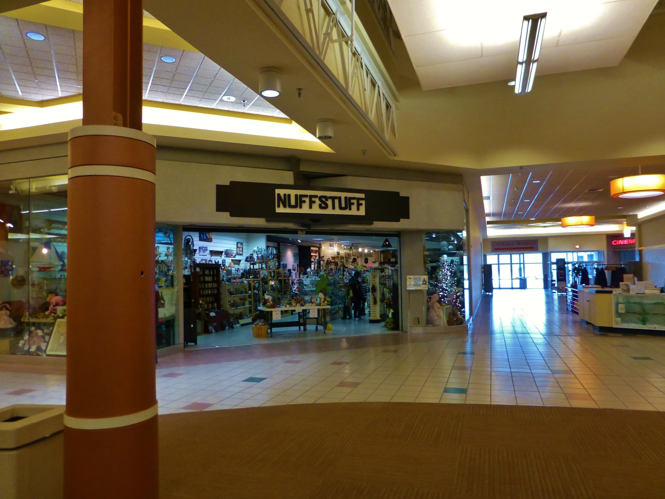 an empty mall with some shops in the background
