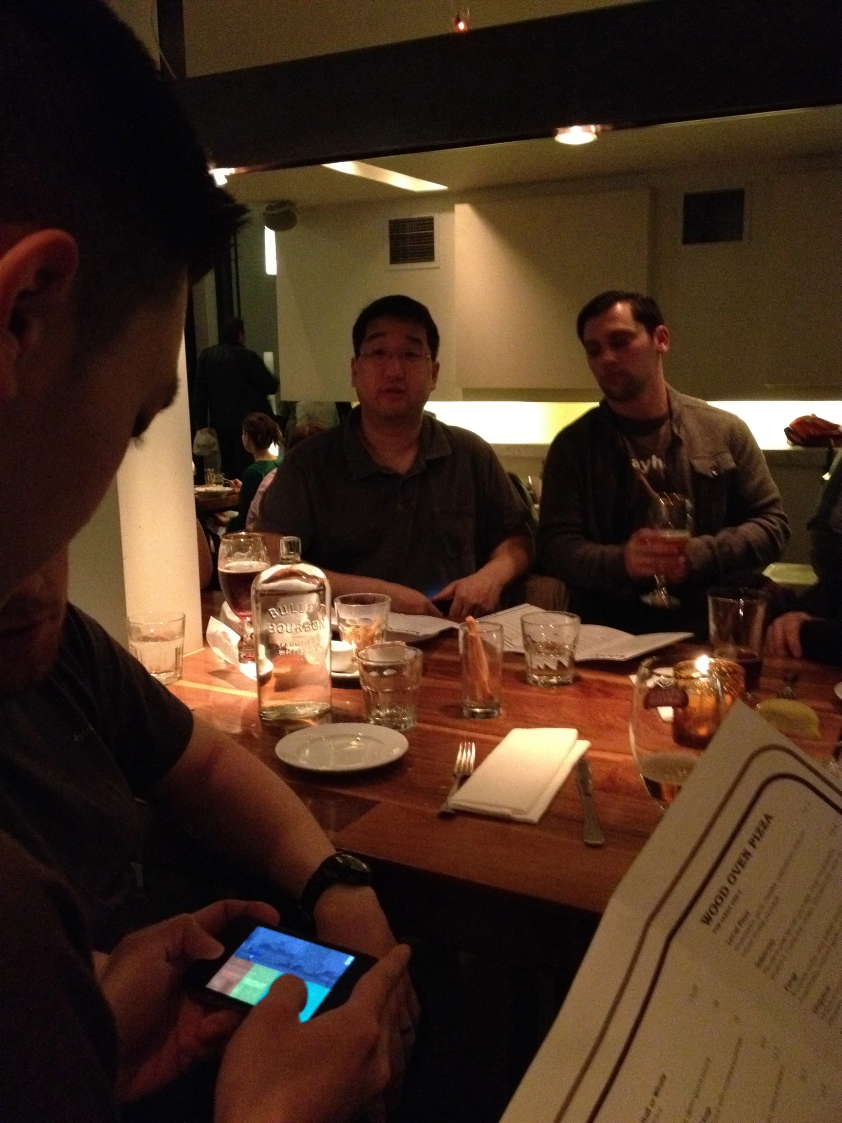 people gathered around a table with drinks and a menu