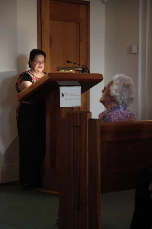 a woman giving a speech at a podium