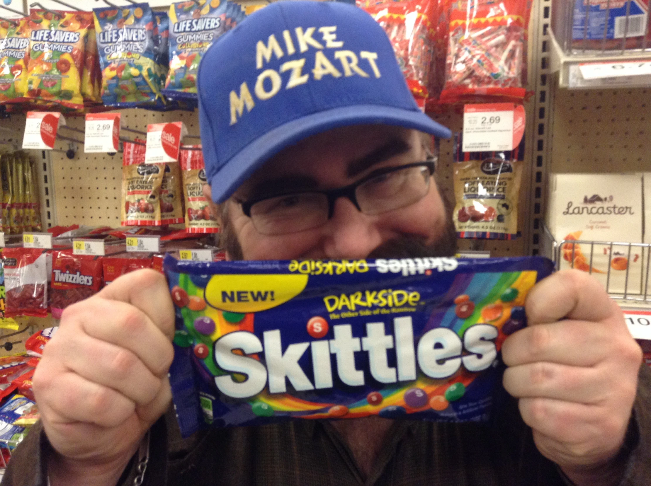 a man is holding a skittle in front of his face