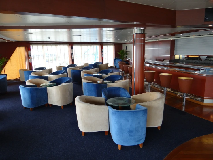 the lounge aboard ship has several blue and beige furniture