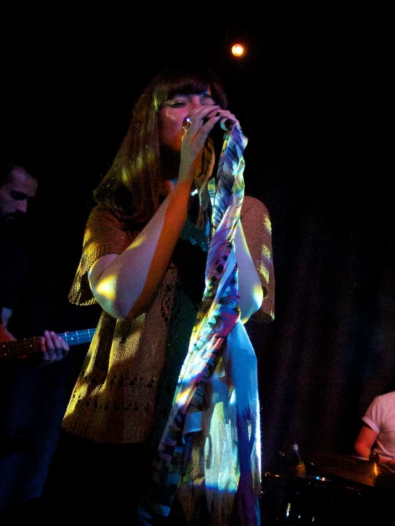 the woman is singing into a microphone on stage