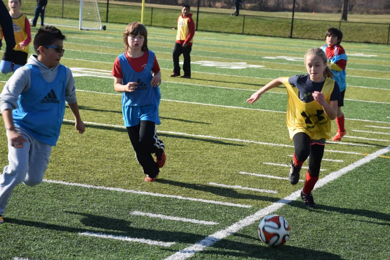 small children playing soccer on a soccer field