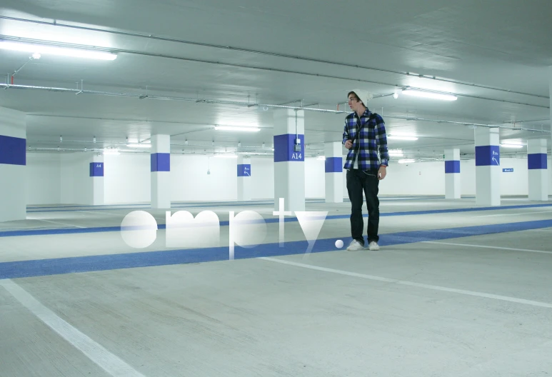 a man walking through an empty parking garage with no one