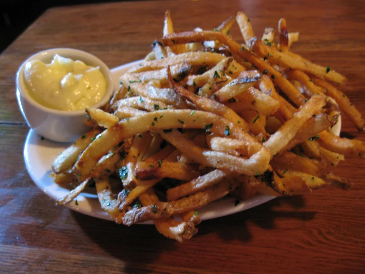 a plate of french fries with er and chives