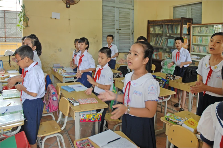 children are in class with the teacher showing them soing