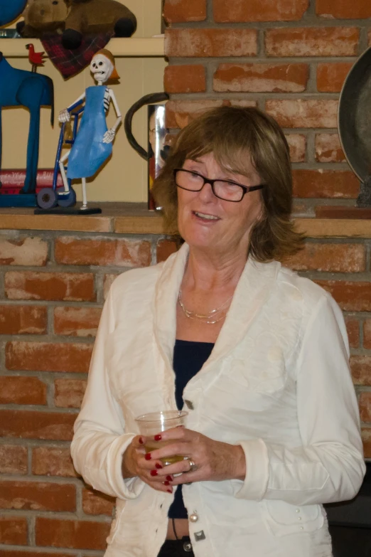 a woman in a white jacket holds a glass