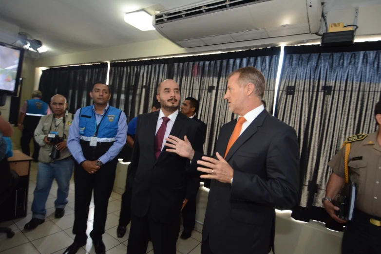 a group of men in suits and ties talking to each other