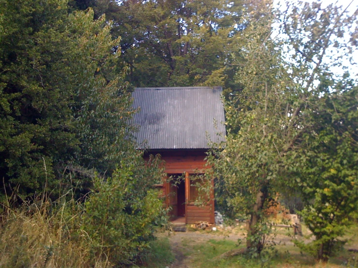 a barn that is surrounded by trees and shrubs