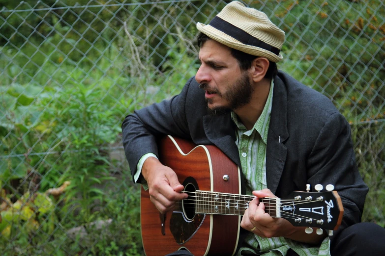 a man is playing an acoustic guitar outside