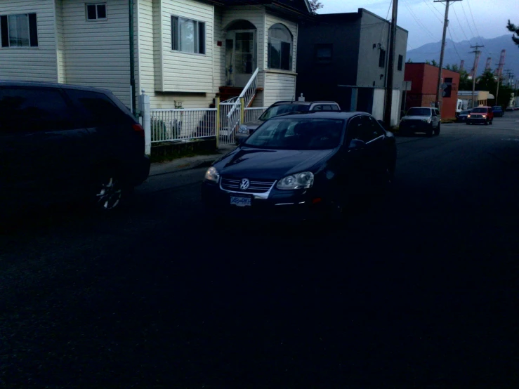 a car driving past a house on a city street