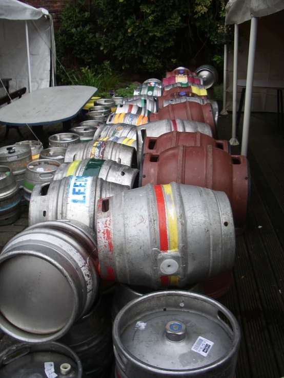 lots of metal barrels with white and red stripes on them