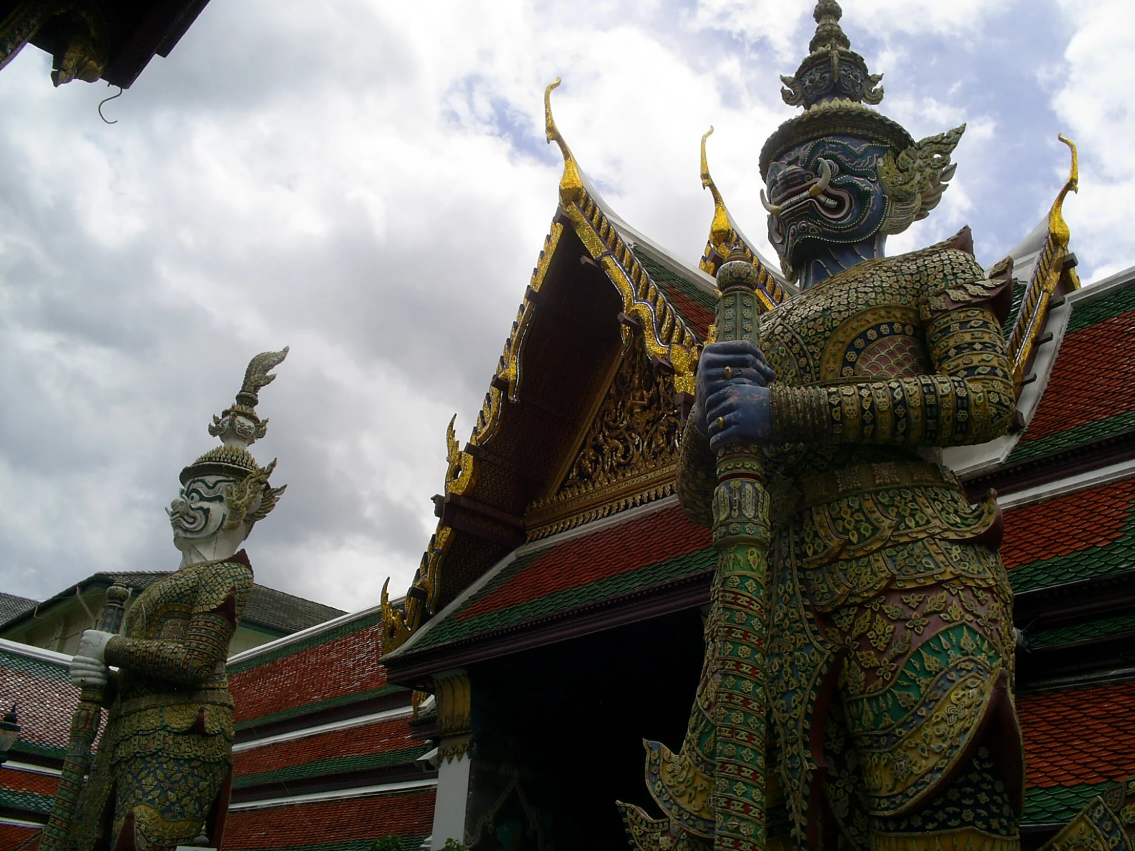 two statues of green men in elaborately designed outfits