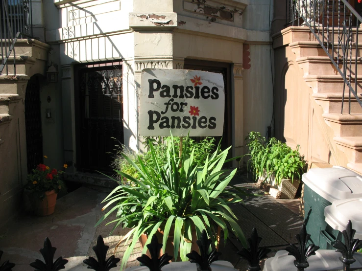 a building with plants and a sign on the front