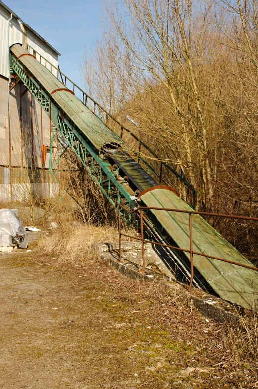 a very big fence by a long piece of green equipment