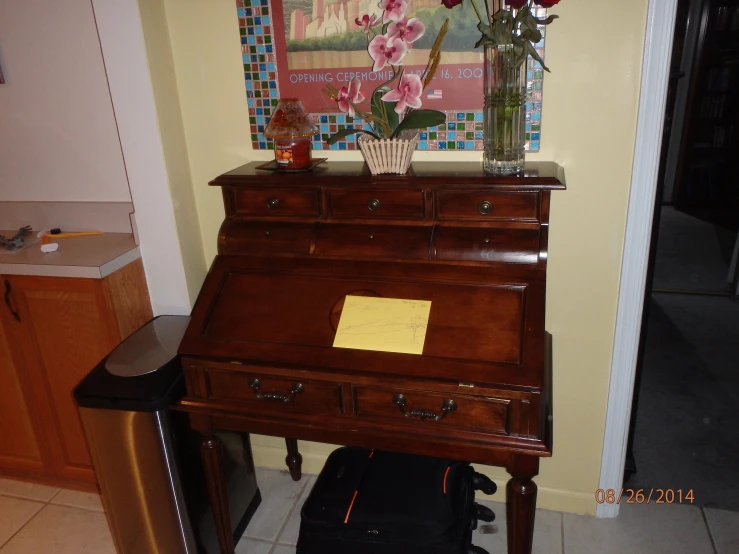 a very old wooden piano with flowers in a vase on top