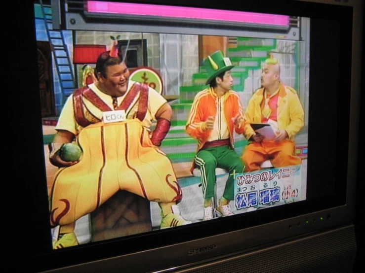 a small television screen with two men dressed in costume on it