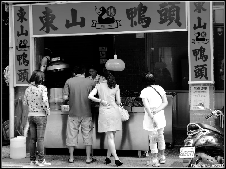 three women wait outside of a food court