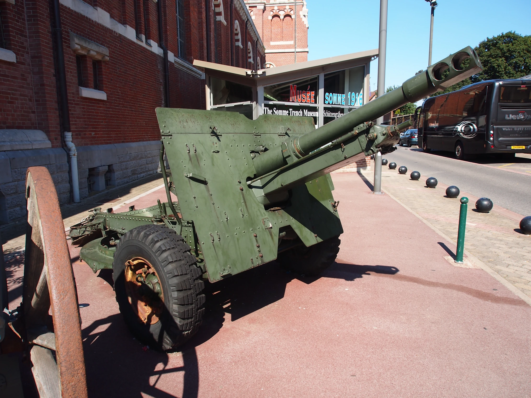 a museum with several green tanks and a metal cannon