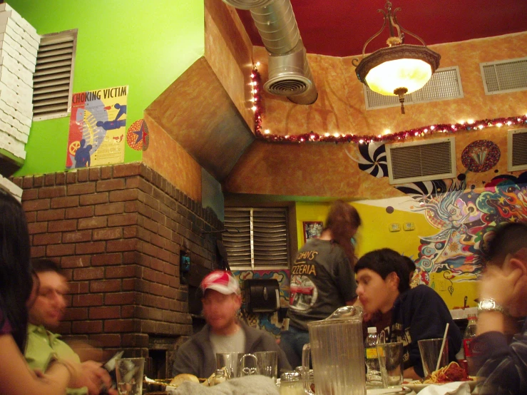 a group of people siting down at tables eating food