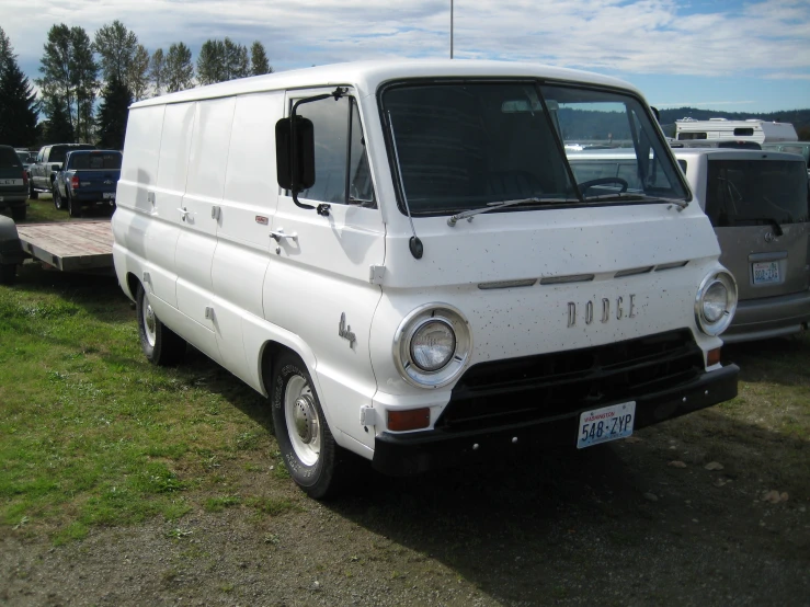 an old white van is parked in a field