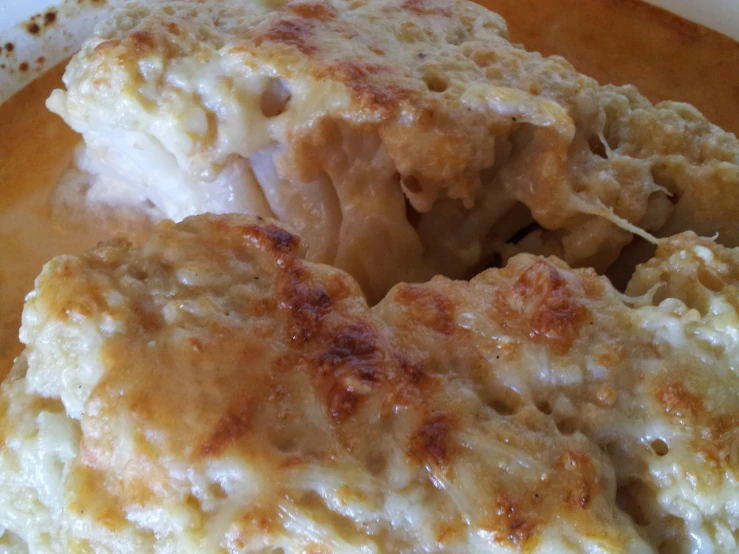 a plate filled with mashed potatoes covered in cheese