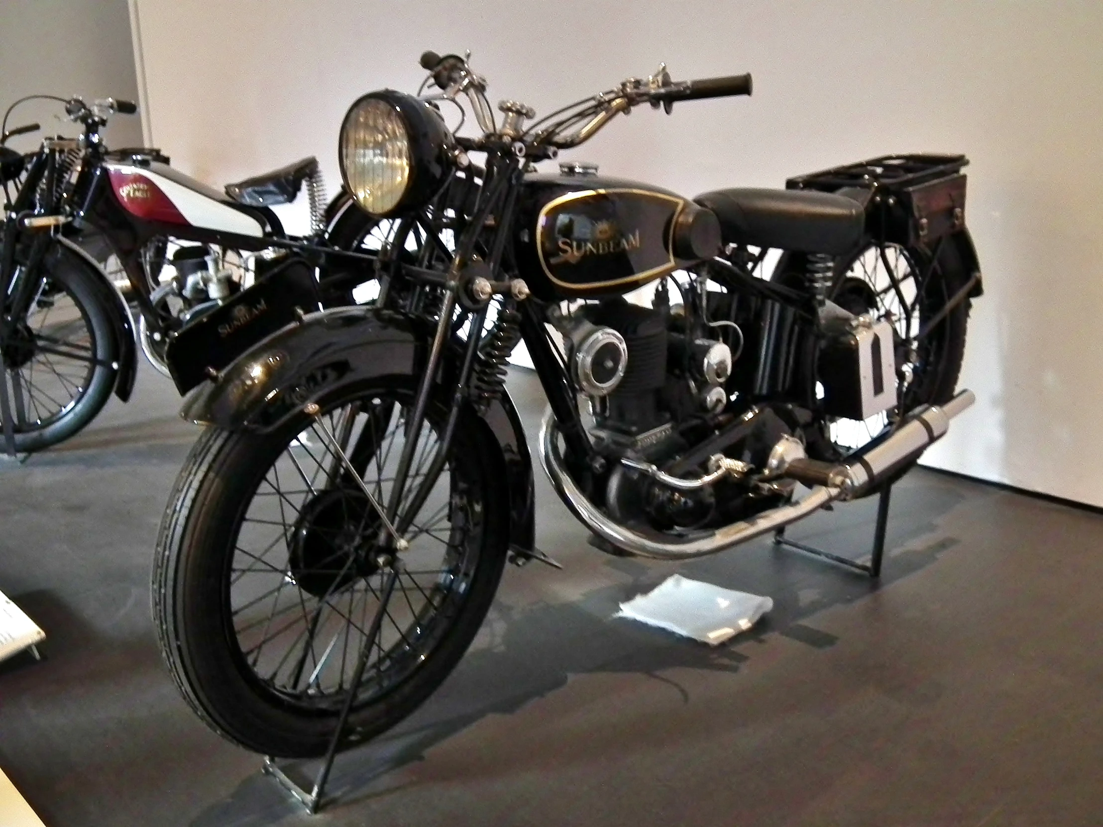 an old motorcycle is sitting in a museum display