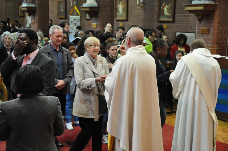 people in robes and standing around during a church service