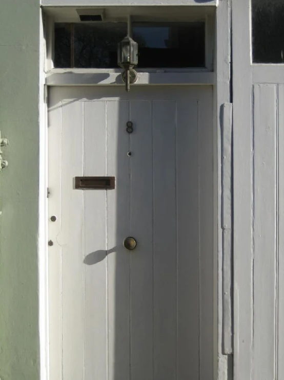 a door sits outside of a house that is painted white