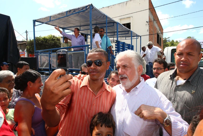 three men posing for the camera in front of an audience