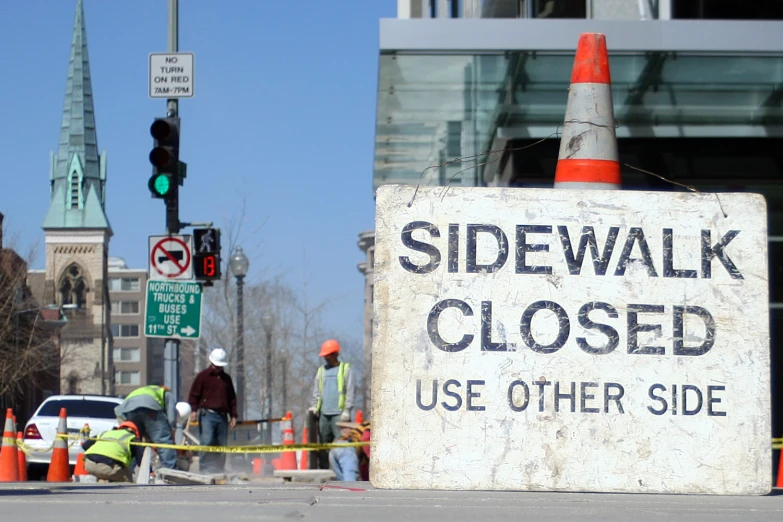 a sidewalk sign and traffic cones next to a building