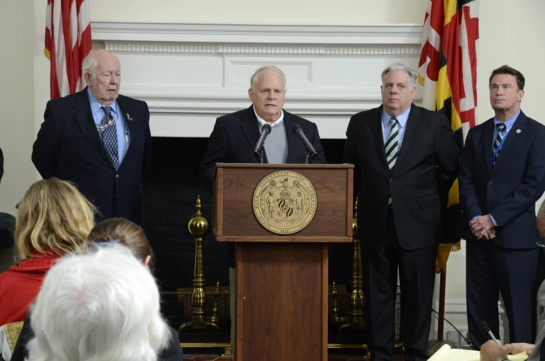 some men are standing at a podium in a room
