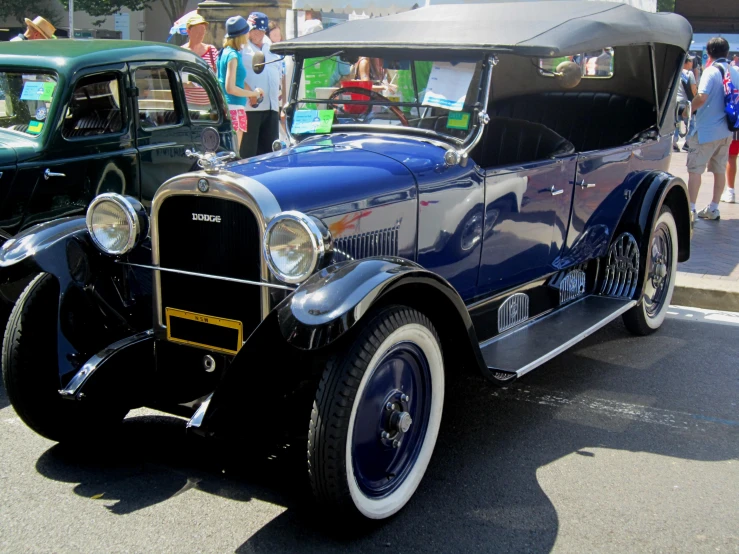 an old, black, vintage car parked at a show