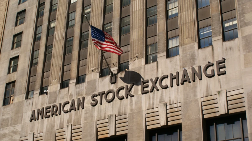 american stock exchange building with an american flag flying in the wind