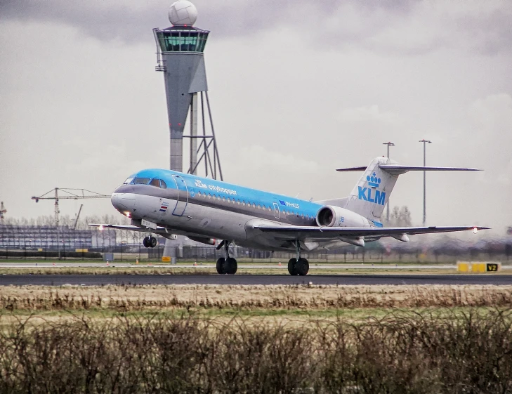 an airplane sitting on the runway in front of a control tower
