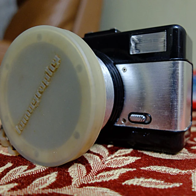 an old style camera on a table in front of a pillow