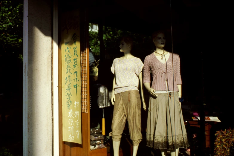 mannequins standing next to each other outside in front of a window